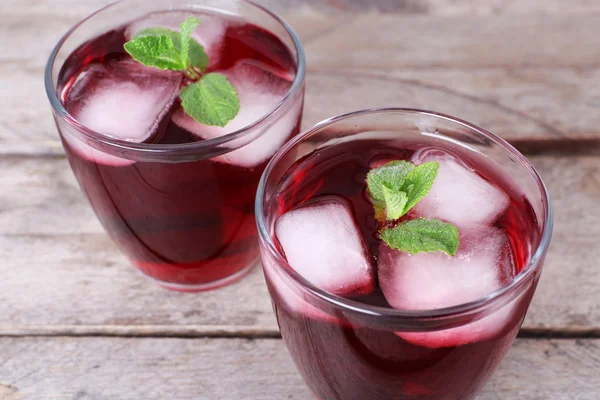 Vasos de soda de cereza con hielo y menta fresca sobre fondo rústico de madera — Foto de Stock