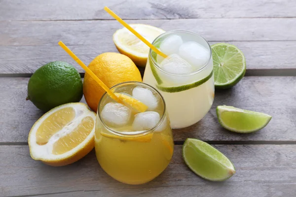 Vasos de refresco de limón con hielo sobre fondo rústico de madera —  Fotos de Stock