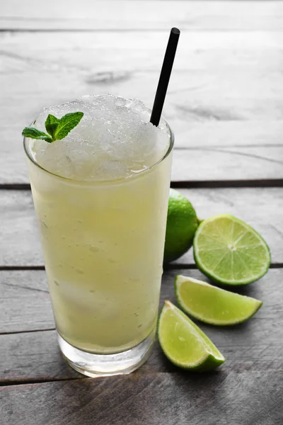 Glass of lemon soda with crushed ice and fresh mint on rustic wooden background — Stock Photo, Image