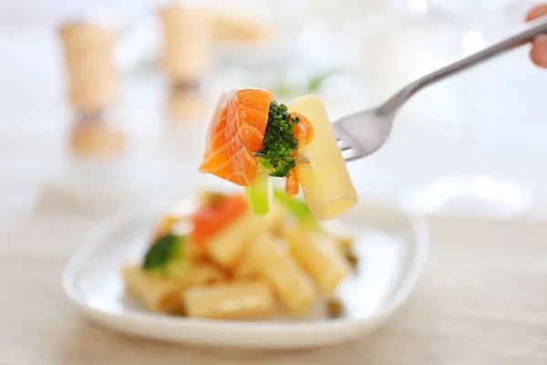 Forquilha com massa rigatoni fervida empalada com salmão e brócolis, close-up — Fotografia de Stock