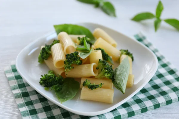 Pasta rigatoni hervida con brócoli y albahaca en plato blanco — Foto de Stock