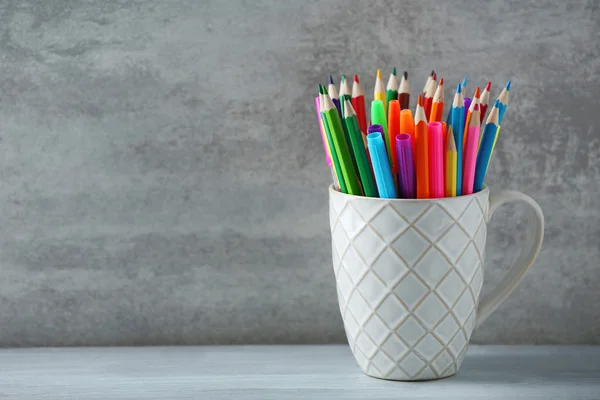 Marqueurs au crayon dans une tasse en céramique — Photo