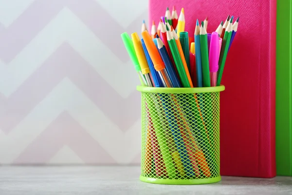 Books pens and markers in metal holder — Stock Photo, Image