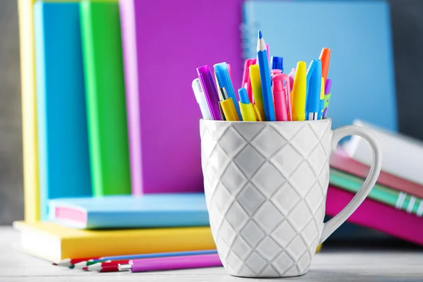 Schreibwaren im Becher auf Büchern — Stockfoto