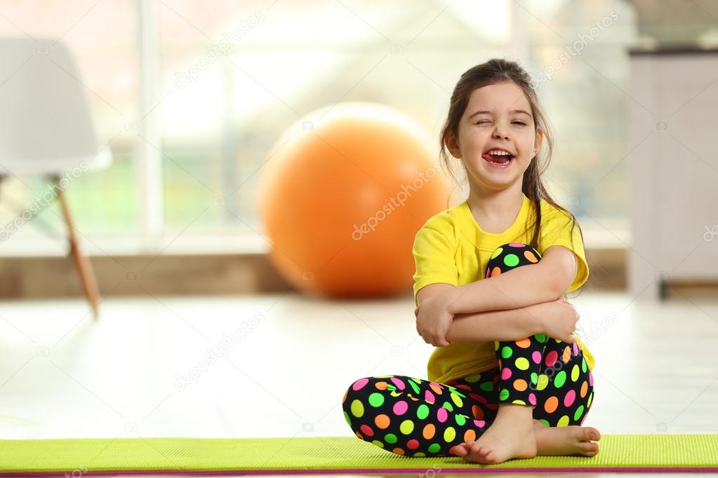 Little girl sitting on a mat