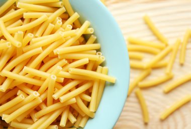 Ahşap masa mavi tabakta kuru maccheroni makarna