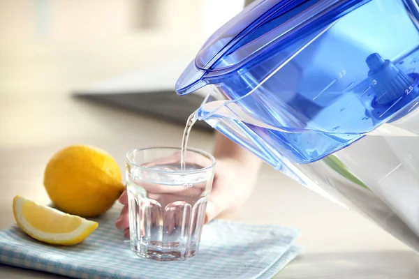 Pouring water from filter jug into glass