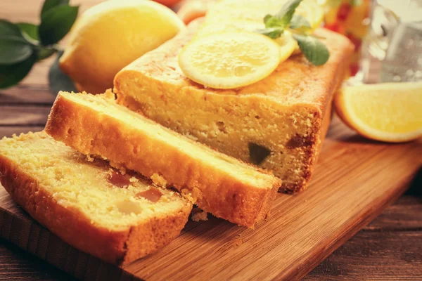 Delicious citrus cake loaf with lemons on wooden board — Stock Photo, Image