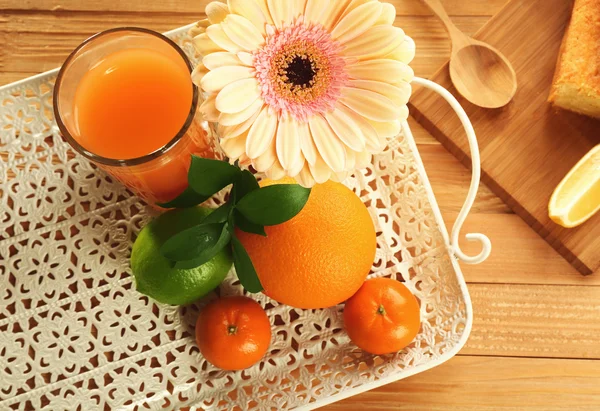 Skivad läcker citrus tårta limpa med frukt och juice på träbord — Stockfoto