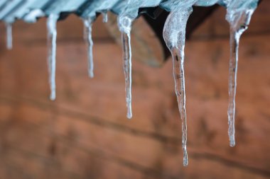 Çatının kenarında asılı buz sarkıtları 