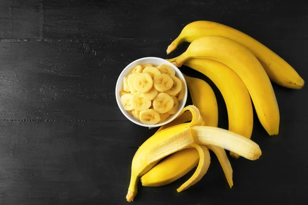 Sliced ripe bananas on black — Stock Photo, Image