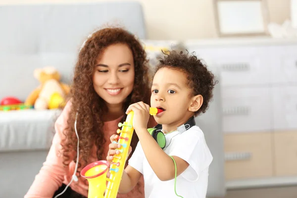 Woman and boy with toy saxophone — Stock Photo, Image