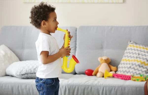 Jongen spelen speelgoed saxofoon — Stockfoto