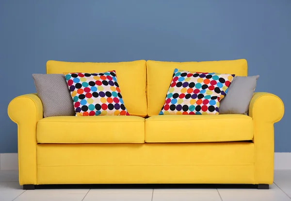 Sofá amarillo y almohadas multicolores —  Fotos de Stock