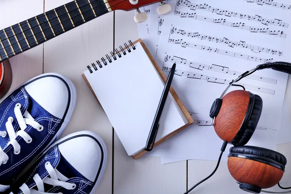 Guitarra, fones de ouvido, folha de música e gomas — Fotografia de Stock