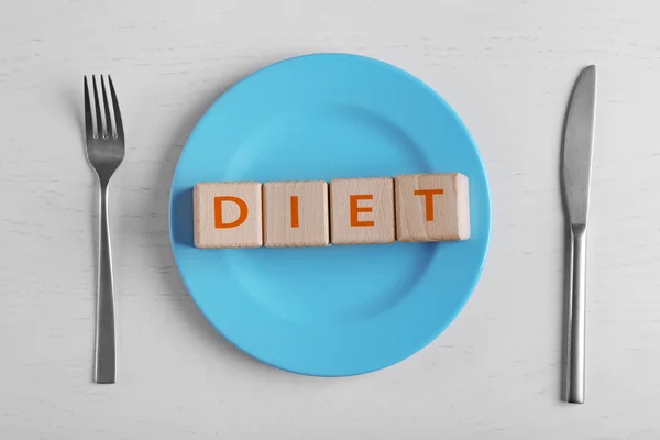 Plate and wooden cubes with text — Stock Photo, Image