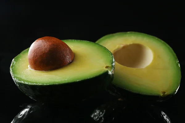 Свежий авокадо на черном — стоковое фото