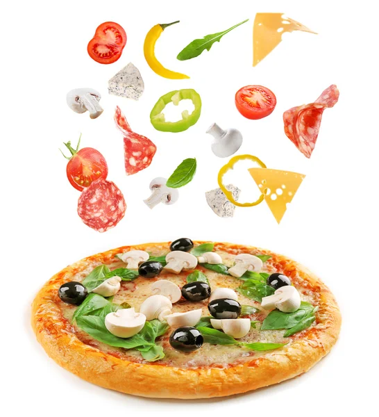 Delicious pizza with falling ingredients — Stock Photo, Image