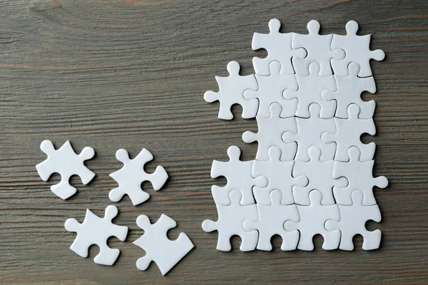 Puzzles on wooden table — Stock Photo, Image