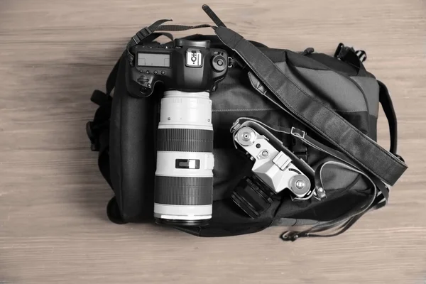 Câmeras novas e antigas em uma mochila — Fotografia de Stock