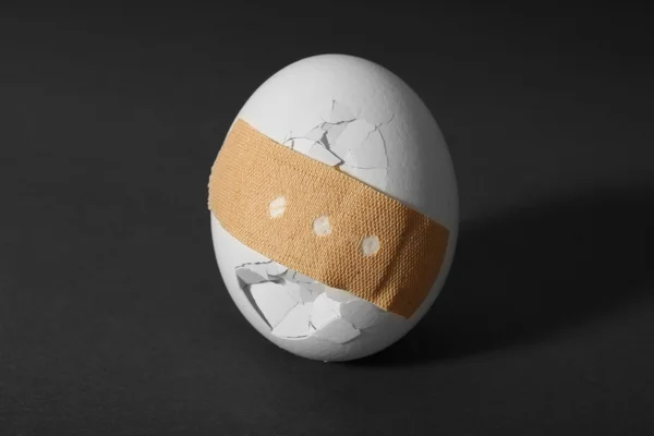 Uovo incrinato su sfondo — Foto Stock