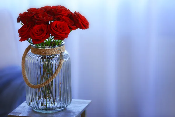 Red roses in a glass jar — Stock Photo, Image