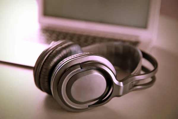 Headphone dan laptop di atas meja — Stok Foto