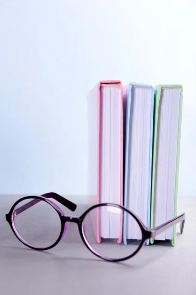 Books and eyeglasses on grey table — Stock Photo, Image