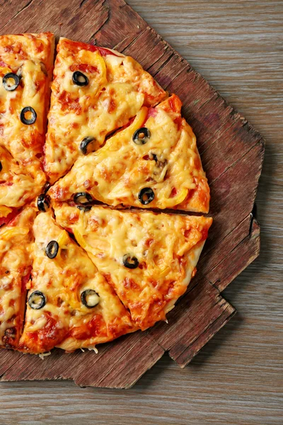 Deliciosa pizza fatiada em tábua de madeira — Fotografia de Stock