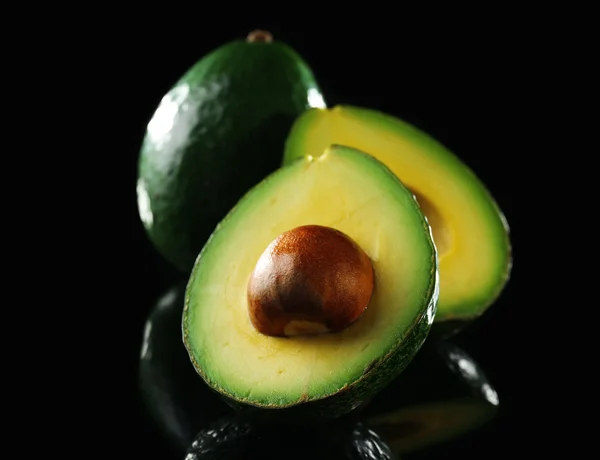 Свежий авокадо на черном — стоковое фото