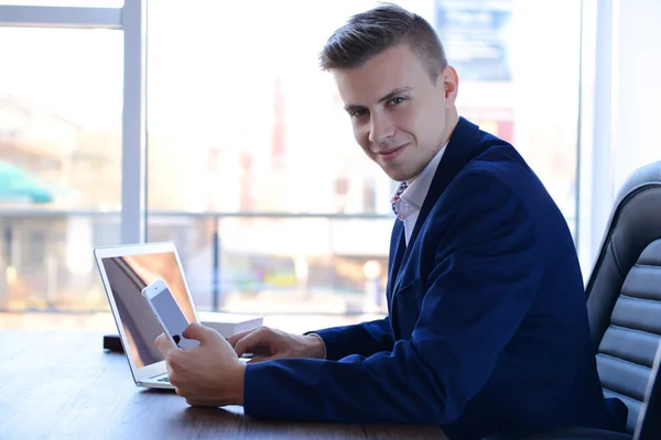 Man using laptop at the table in office — Stock Photo, Image