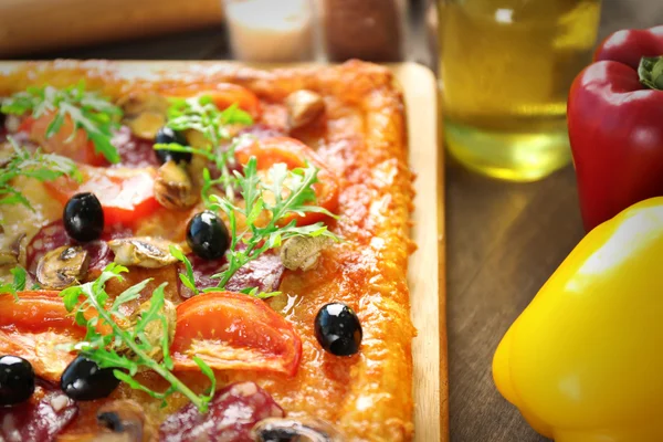 Rectangle délicieuse pizza et légumes sur la table, gros plan — Photo