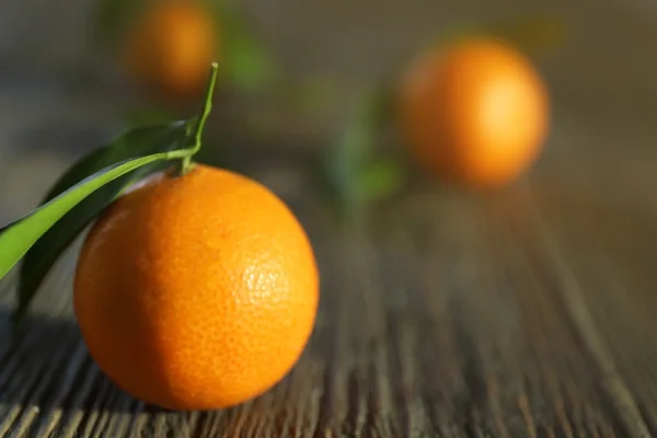 Mandarines fraîches avec feuilles sur table en bois, gros plan — Photo