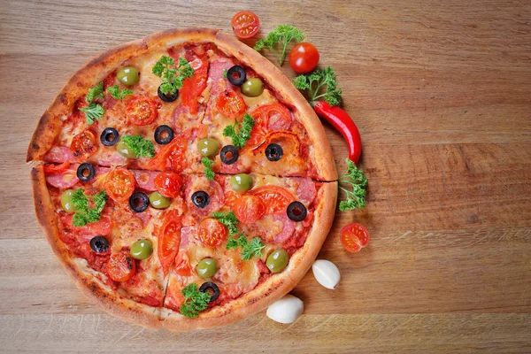 Pizza saborosa com salsicha e legumes em fundo de mesa de madeira — Fotografia de Stock