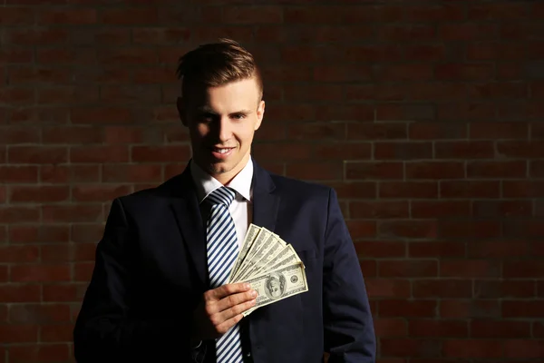 Привлекательный мужчина держит фаната банкнот — стоковое фото
