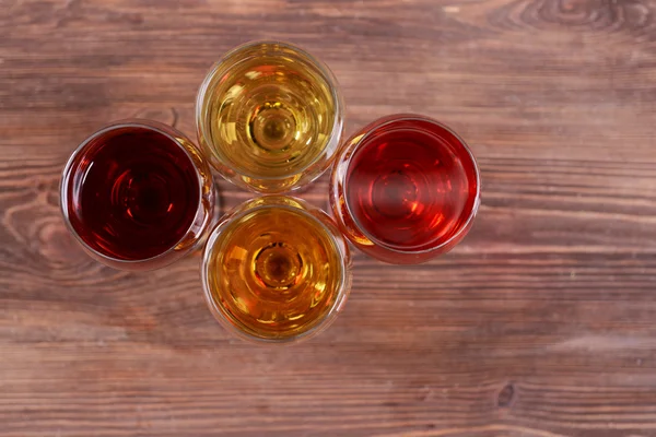 Copos com vinhos de cores diferentes em uma mesa de madeira — Fotografia de Stock