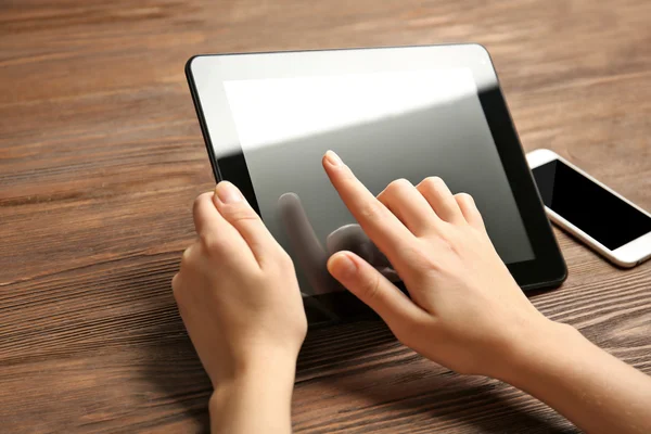 Мобильный телефон и женские руки с помощью планшета — стоковое фото