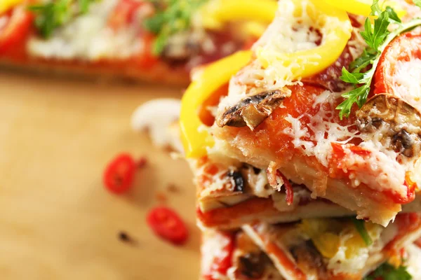 Dilim lezzetli pizza masada, yakın çekim — Stok fotoğraf