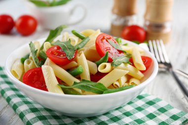 Penne makarna domates, Fransızca fasulye ve beyaz tabakta roka ile haşlanmış