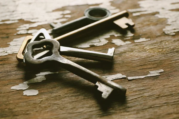 Four keys on old crack background, close up — Stock Photo, Image