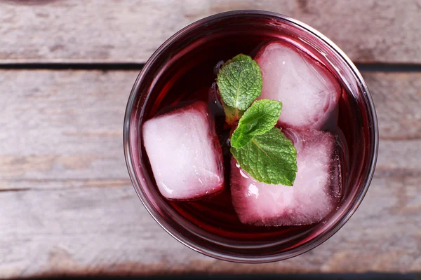 Glass of cherry soda with ice and fresh mint on rustic wooden background — Stock Photo, Image