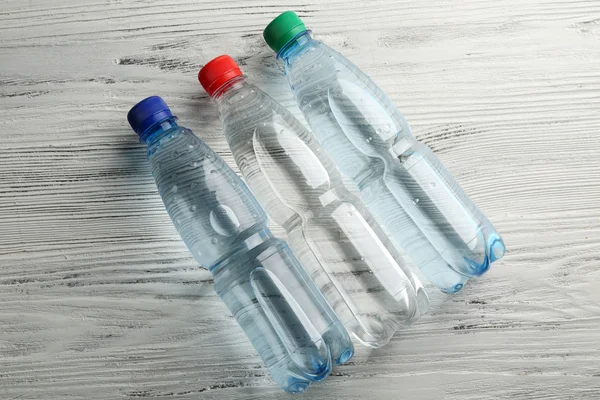 Bottled water on the wooden table, top view — Stock Photo, Image