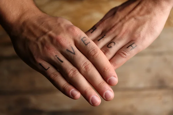 Tattoo inscriptions on male fingers — Stock Photo, Image