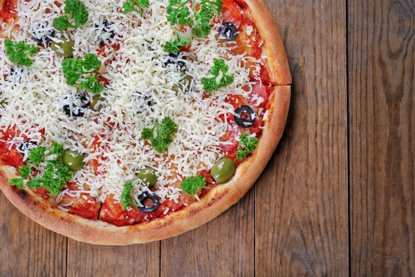 Pizza sajttal, fából készült asztal háttér — Stock Fotó