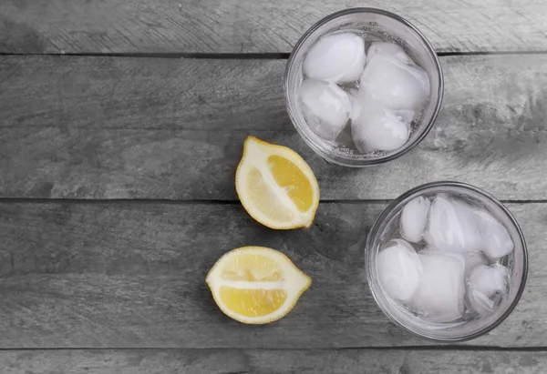 Glasses of water and sliced lemon on wooden table, top view — Stock Photo, Image