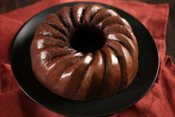 木製の背景の黒のプレートにチョコレート ケーキ — ストック写真