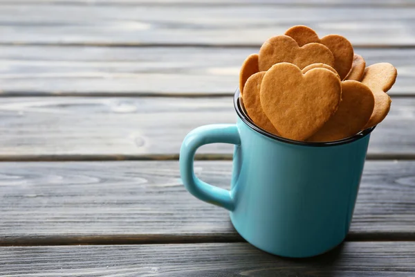 Heart shaped biscuits in metal mug on wooden background — Stock Photo, Image