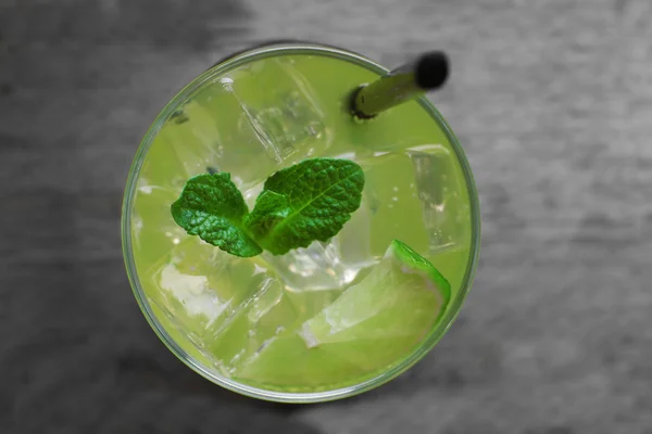 Glass of lemon soda with fresh mint on rustic wooden background