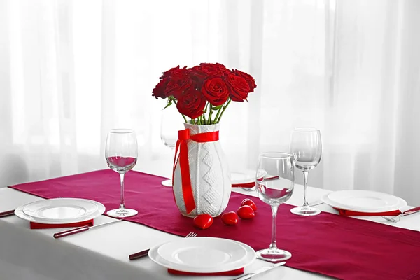 Vase with red roses on served table — Stock Photo, Image