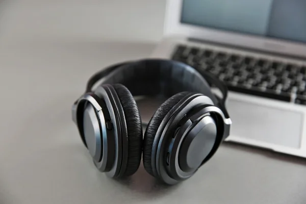 Fones de ouvido e laptop na mesa — Fotografia de Stock